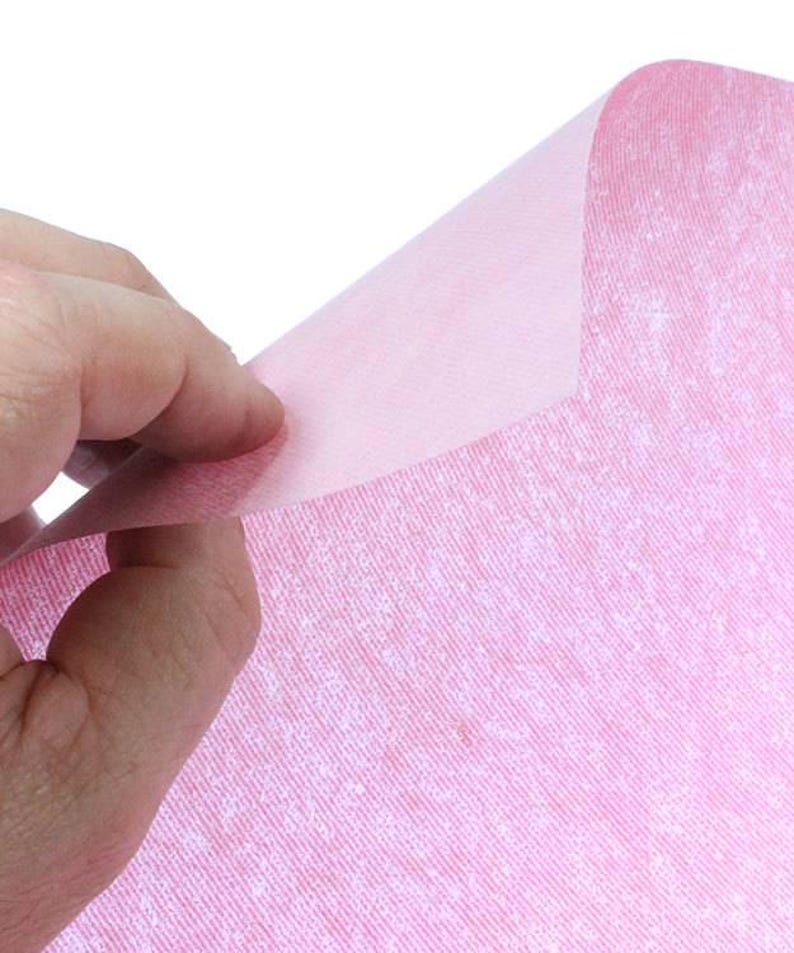 May include: A sheet of pink tissue paper with a subtle textured pattern. The paper is translucent and has a slightly crinkled appearance.