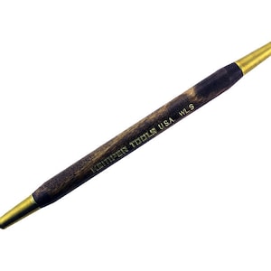 May include: A Kemper Tools USA WLS double-ended sculpting tool. The tool has a dark wooden handle with brass-colored metal tips. One end has a loop, and the other has a rounded tip. The text "KEMPER TOOLS USA WLS" is printed on the handle.