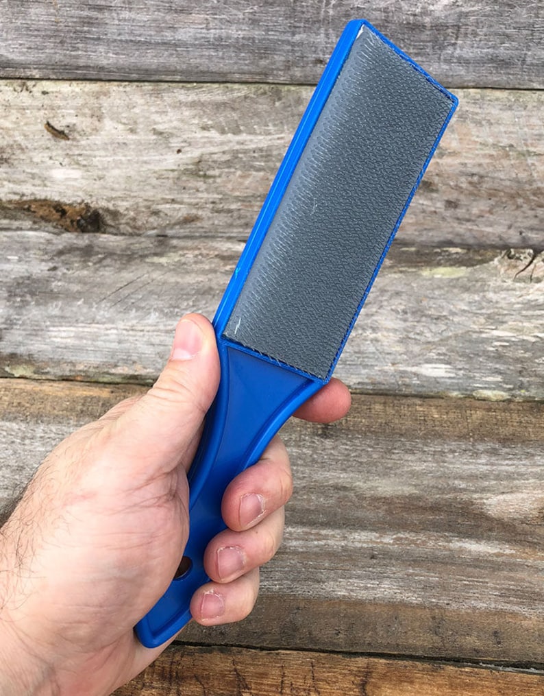 May include: A blue plastic hand-held file with a gray abrasive surface.