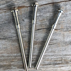 May include: Three silver metal mandrels for a rotary tool. The mandrels are about 3 inches long and have a cylindrical shape.