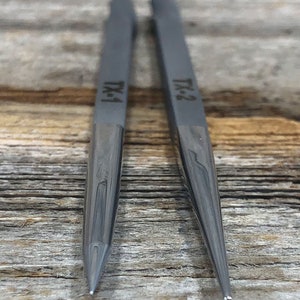 May include: Two gray metal tools with pointed tips. The tools are labeled "TK-1" and "TK-2".