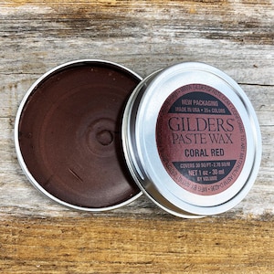 May include: A small tin of Gilders Paste Wax in Coral Red. The tin is open and the wax is visible. The label on the tin says "Gilders Paste Wax Coral Red" and "Covers 30 sq ft - 2.78 sq m Net 1 oz - 30 ml by volume".