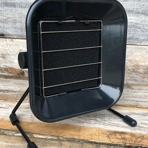 May include: Black soldering fume extractor with a black metal mesh filter and a black plastic base. The extractor has two black metal legs.