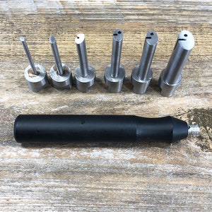 May include: A set of seven metal tools with different shaped tips, and a black handle. The tools are used for crafting and jewelry making.