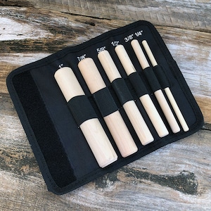 May include: A black fabric case with seven wooden dowels of varying sizes. The dowels are labeled with their diameter in inches: 1", 7/8", 5/8", 1/2", 3/8", 1/4".