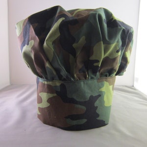 May include: Camouflage chef hat with a green, brown and black pattern.