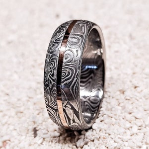 Bifrost - A Stainless Damascus Steel Ring, Hand Forged With An Inlay Of Rose Gold