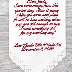 Puede incluir: Un pa&ntilde;uelo blanco con ribete de encaje y texto bordado en rojo y rosa. El texto dice "Elsie Jade, Save some magic from this special day Stow it away while you grow and play. It will be here waiting when you are old enough to say "I need something old for my wedding day." Love Auntie Ellie & Uncle Sal December 2, 2022"