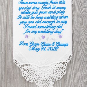 Puede incluir: Un pa&ntilde;uelo blanco bordado con bordados azules y morados. El texto dice "Adelaide Rae Save some magic from this special day. Tuck it away while you grow and play. It will be here waiting when you are old enough to say "I need something old for my wedding day" Love, Gram-Gram & Grampo May 14, 2022"