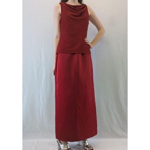 May include: A long red dress with a cowl neck top and a matching skirt. The top is made of a sparkly fabric.