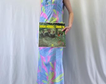 Vestido largo de corte imperio de Martinette of Sweden de la década de 1960 con estampado floral gráfico en tonos pastel morados, rosas, azules y verdes.