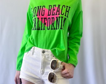 Top deportivo popular de los años 90, color verde neón, estilo Long Beach, California, con cuello barco y manga larga.