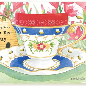 Just Bee-cause, een theekopje-wenskaart met zoemende bijen en een English Breakfast-theezakje van kunstenaar Kimberly Shaw
