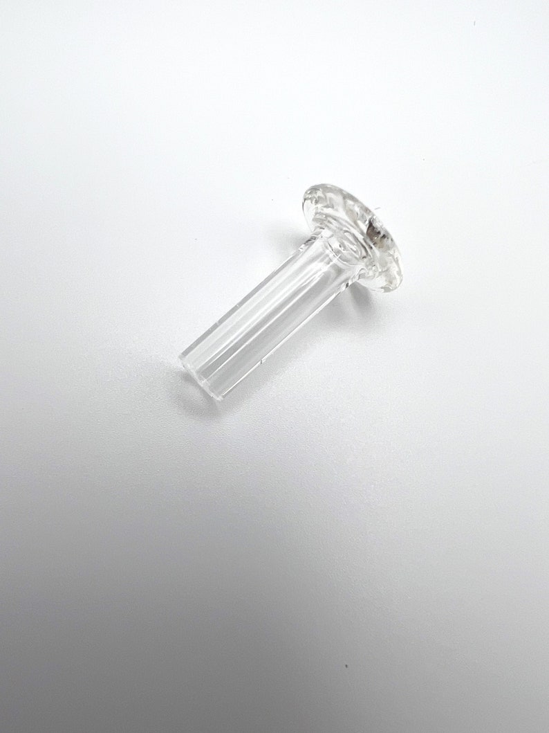 May include: A clear glass downstem with a flared, flat top. The downstem is designed to fit into a glass water pipe.