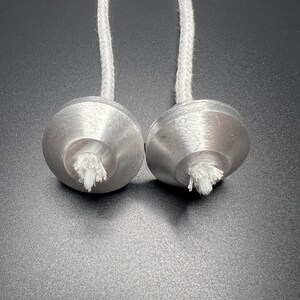 May include: Two silver wick holders with white wicks and white cotton cords.