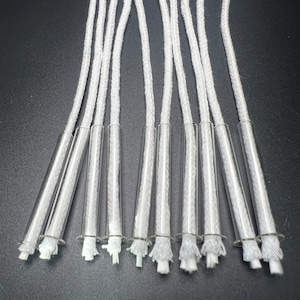May include: Ten white cotton wicks in clear glass tubes. The wicks are frayed at the ends.