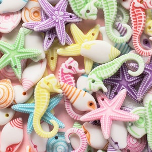 May include: Assortment of colorful plastic seahorse and starfish charms. The charms are in various shades of blue, green, pink, purple, and yellow. They are perfect for adding a touch of whimsy to jewelry, crafts, and other projects.