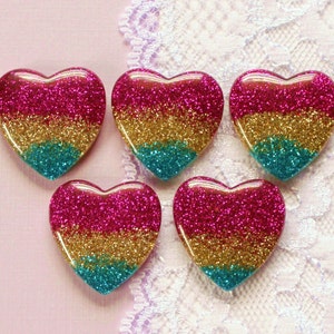 May include: Five heart-shaped glitter ornaments in pink, gold, and teal.