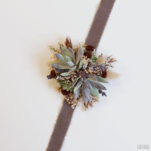 May include: A brown velvet ribbon with a dried floral wrist corsage featuring succulents, lavender, and dried grasses.