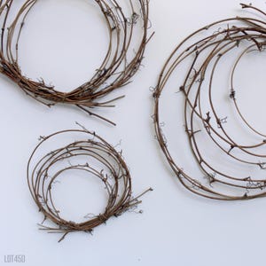 May include: Three brown grapevine wreaths of varying sizes. The wreaths are made of natural grapevine branches and are perfect for crafting.