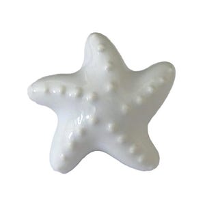 May include: A white ceramic starfish with a textured surface. The starfish is a popular nautical decor item.