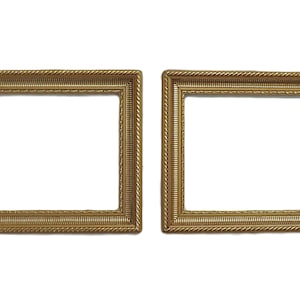 May include: Two rectangular gold picture frames with ornate detailing. The frames have a textured, rope-like design along the edges and a smooth, flat surface for the picture. The frames are empty, with a white background.