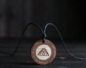 May include: A wooden pendant necklace with a black cord. The pendant is round and features a geometric design with a triangle and a symbol inside. The pendant is made of light brown wood.