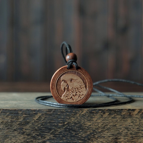 Parrot Necklace/Pendant. Made from solid sycamore wood. Round shape. Brown color. Adjustable cotton cord. Text customization.