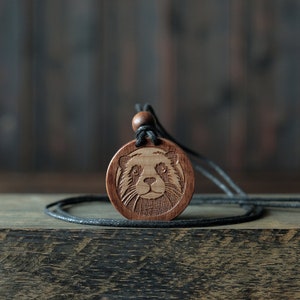 Otter Necklace/Pendant. Made from solid sycamore wood. Round shape. Brown color. Adjustable cotton cord.