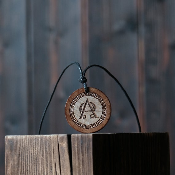 Alpha and Omega Necklace/Pendant. Made from solid wood. Brown colour, round shape. Adjustable black cotton cord.