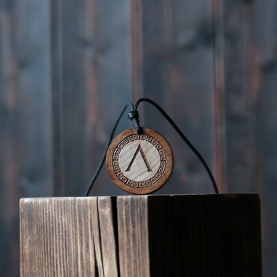 Spartan Lambda  Necklace/Pendant. Made from solid wood. Brown colour, round shape. Adjustable black cotton cord.
