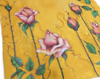 May include: A square scarf in a vibrant mustard yellow hue featuring a hand-painted design of several pink rose blossoms and buds on long, thorny green stems with detailed leaves. The artwork includes delicate, flowing line work throughout.