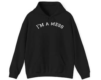 May include: A black long-sleeve hooded sweatshirt featuring a front kangaroo pocket and the text I'M A MESS printed in white capital letters in an arched layout across the chest area. The garment includes a drawstring hood and ribbed cuffs.