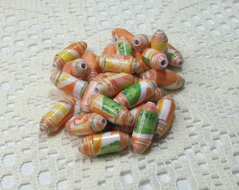 May include: A collection of colorful paper beads with a fruit print design. The beads are orange, yellow, and green and have a rolled paper construction.
