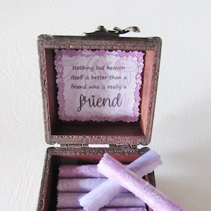 May include: A wooden box with a hinged lid and a quote inside that reads "Nothing but heaven itself is better than a friend who is really a friend". The box is filled with purple scrolls.
