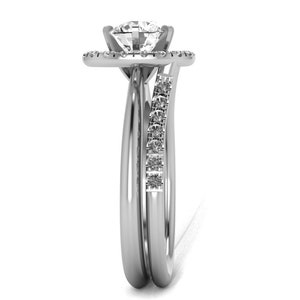 May include: A silver engagement ring set with a round center stone and a halo of smaller stones. The band is accented with a row of smaller stones.