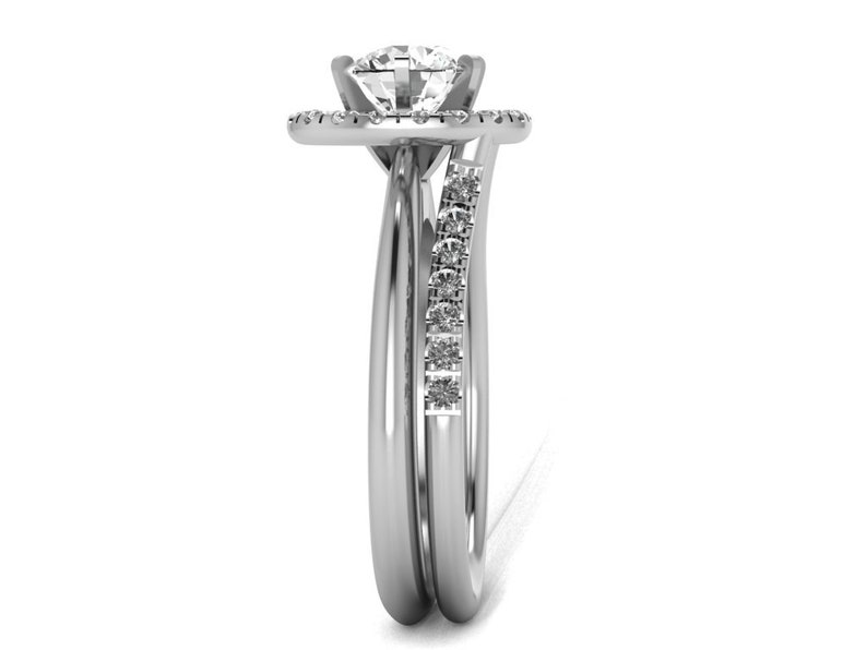 May include: A silver engagement ring set with a round center stone and a halo of smaller stones. The band is accented with a row of smaller stones.