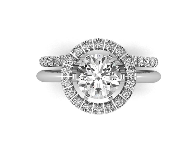 May include: A silver engagement ring set with a round center stone and a halo of smaller stones. The band is also set with smaller stones.