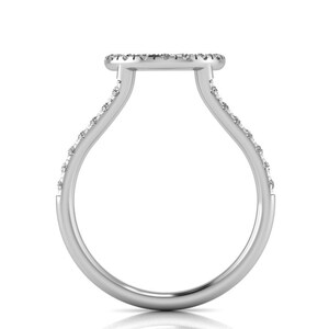 May include: A silver ring with a round, pave-set diamond center and a band that is set with smaller diamonds.