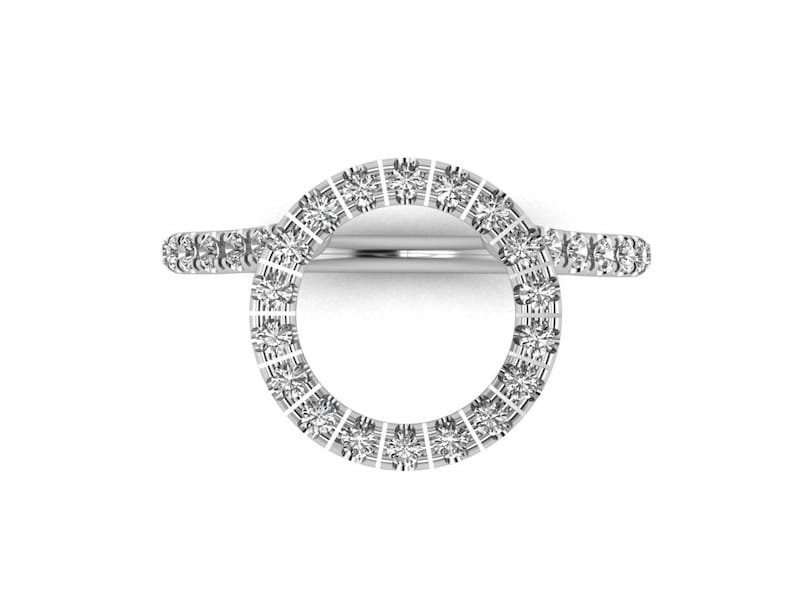 May include: A silver ring with a circle of small diamonds. The ring is designed to be worn on the finger with the circle of diamonds facing outward.