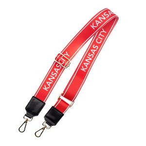 May include: Red adjustable strap with white text that reads "KANSAS CITY" on both sides. The strap has gold metal clasps.