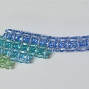 May include: A light green, blue, and purple beaded keychain with a silver key ring.