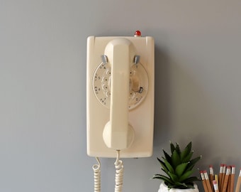 Beige rotary dial wall phone with light, restored and working