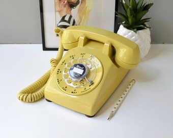 Vintage rotary phone restored and working, retro desk phone in yellow