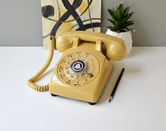 Vintage rotary phone restored and working, retro desk phone in yellow