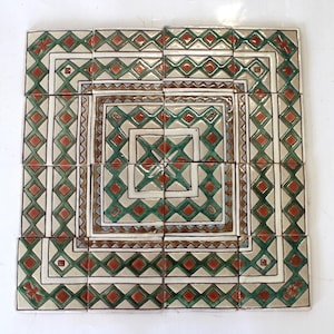 May include: A square tile mosaic with a geometric pattern in shades of green, brown, and white. The tiles are arranged in a symmetrical pattern, creating a visually appealing design.