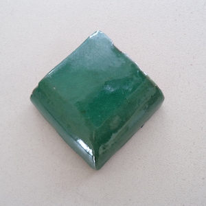 May include: A green diamond-shaped ceramic tile with a glossy finish.