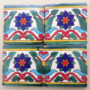 May include: Four square ceramic tiles with a repeating pattern of blue, red, yellow, and green stylized flowers. The tiles are arranged in a 2x2 grid.
