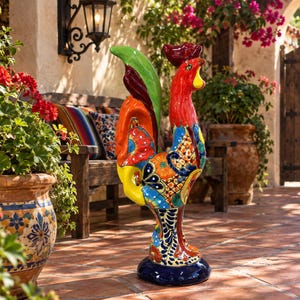 May include: A standing ceramic rooster figurine featuring a vibrant, multi-colored Talavera-style pattern. The rooster has a bright red head, a green tail, and a body decorated with intricate floral and geometric designs in yellow, blue, and orange.