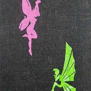 Könnte beinhalten: Zwei Feensilhouetten, die aus Papier ausgeschnitten und auf einen schwarzen Stoffhintergrund geklebt wurden. Die Fee links ist rosa und die Fee rechts ist grün.